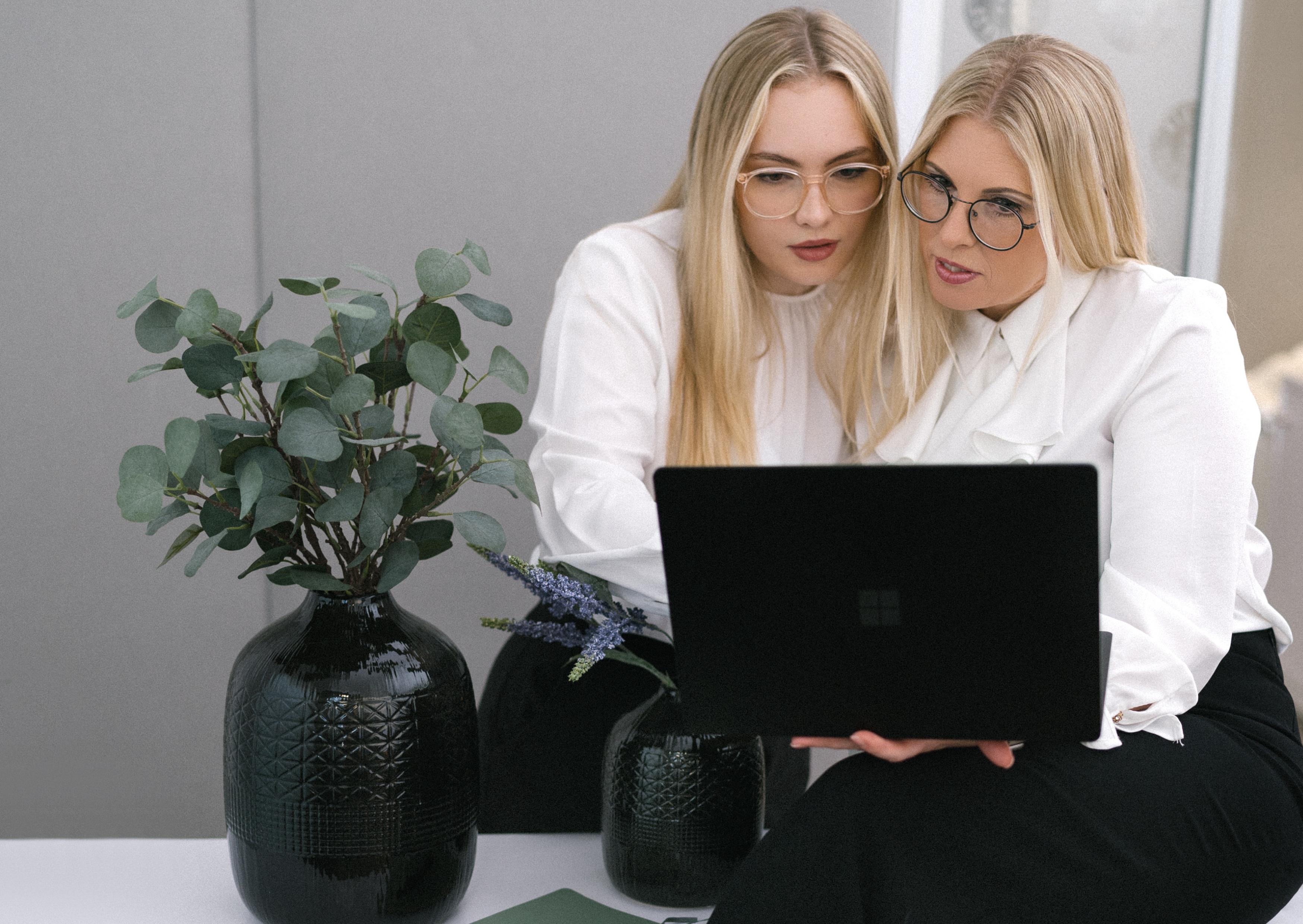 Zwei Personen die gemeinsam auf einen Laptop schauen bzw. damit arbeiten.